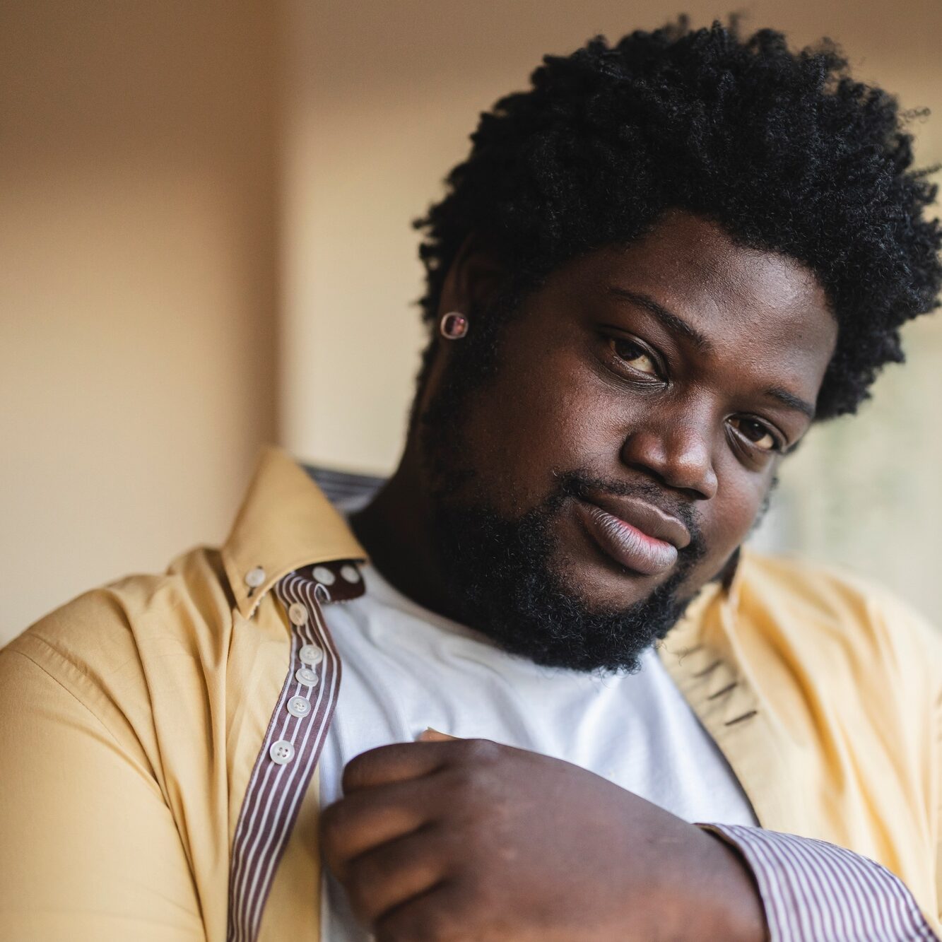 Close up portrait of african man curvy with curly hair at home.